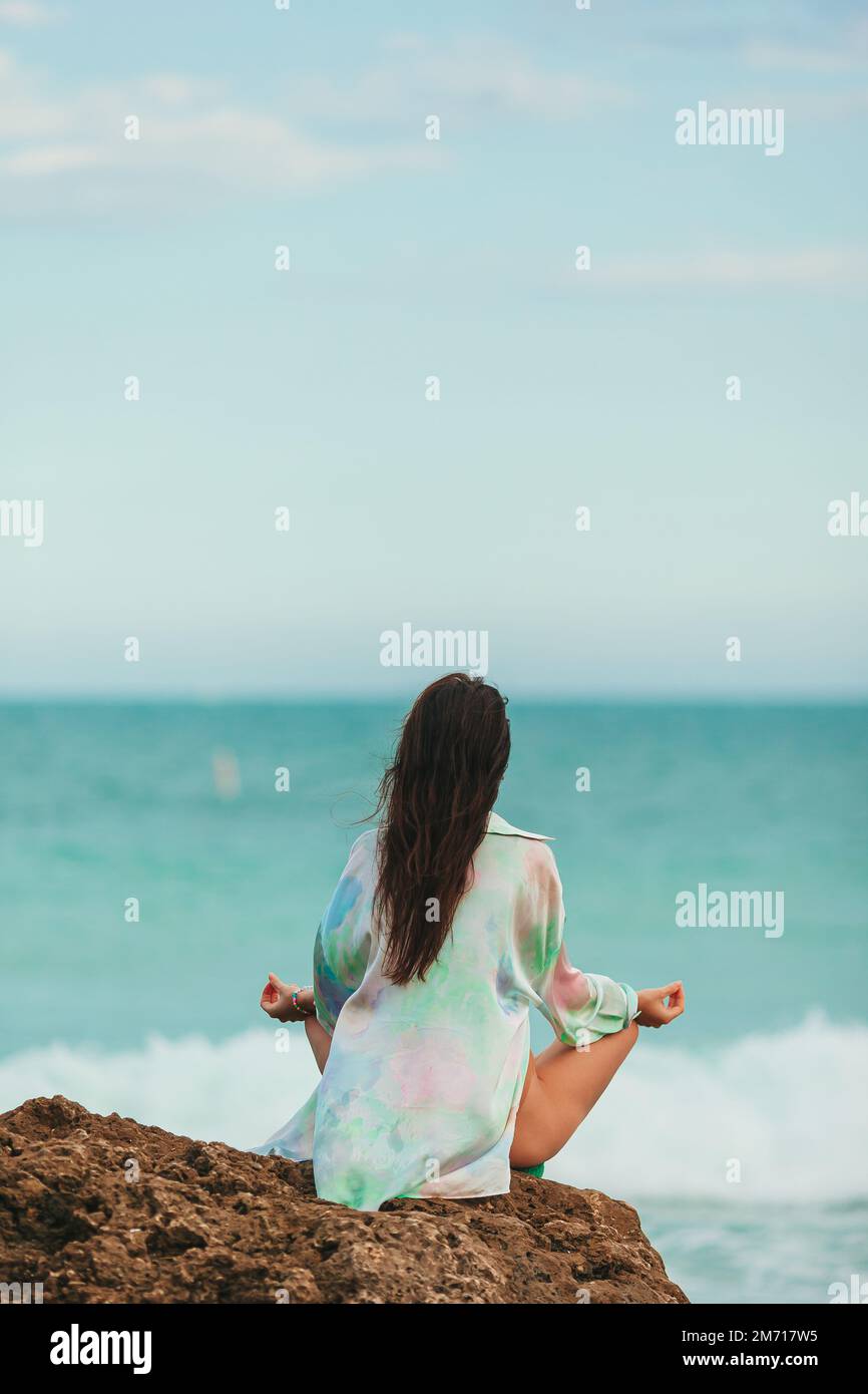 Junge Frau mit Yoga am Strand Stockfoto
