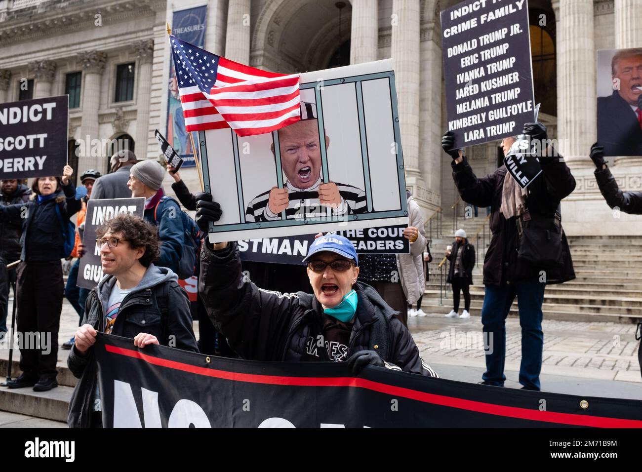 New York, New York, USA. 6. Januar 2023. Demonstranten, unterstützt von der Redefreiheit für Menschen, treffen sich auf den Stufen des Stephen A. Schwarzman-Gebäudes der New York Public Library zum zweiten Jahrestag des Angriffs auf die USA Kapitol. Eine Frau hält eine amerikanische Flagge und ein Schild, auf dem Trump in Gefängniskleidung und hinter Gittern zu sehen ist. Kredit: Ed Lefkowicz/Alamy Live News Stockfoto