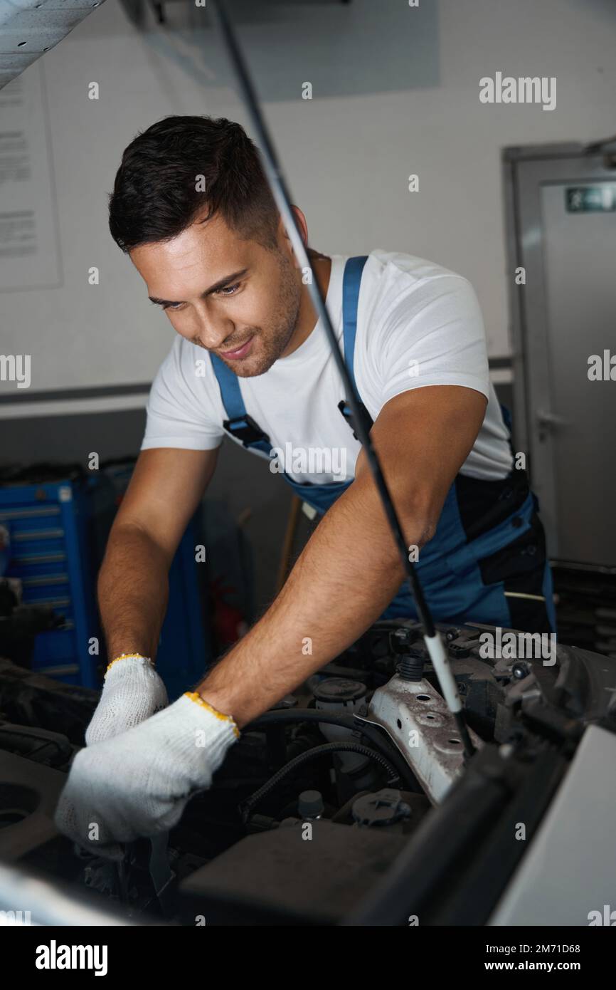 Porträt eines jungen Mechanikers, der Autoreparaturen durchführt Stockfoto