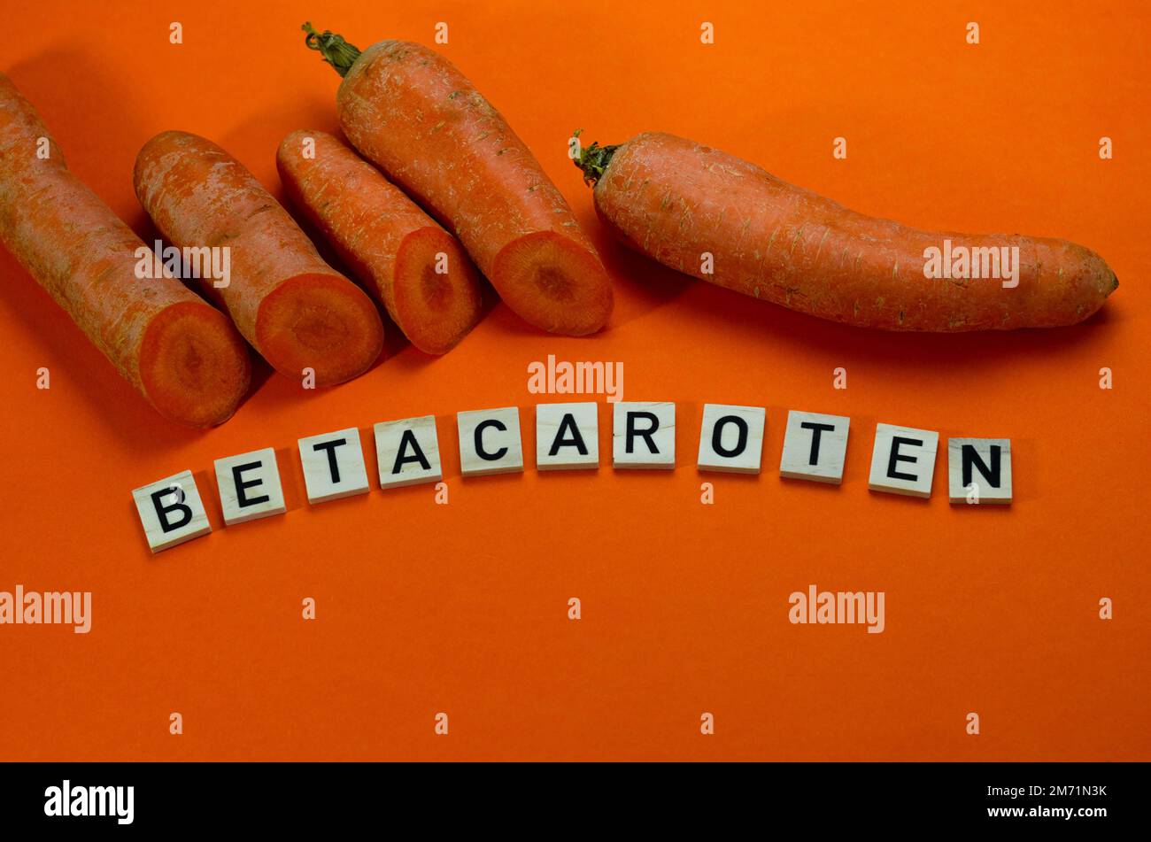 Orangefarbene Karotten auf orangefarbenem Hintergrund mit Draufsicht. Betacaroten-Konzept Stockfoto