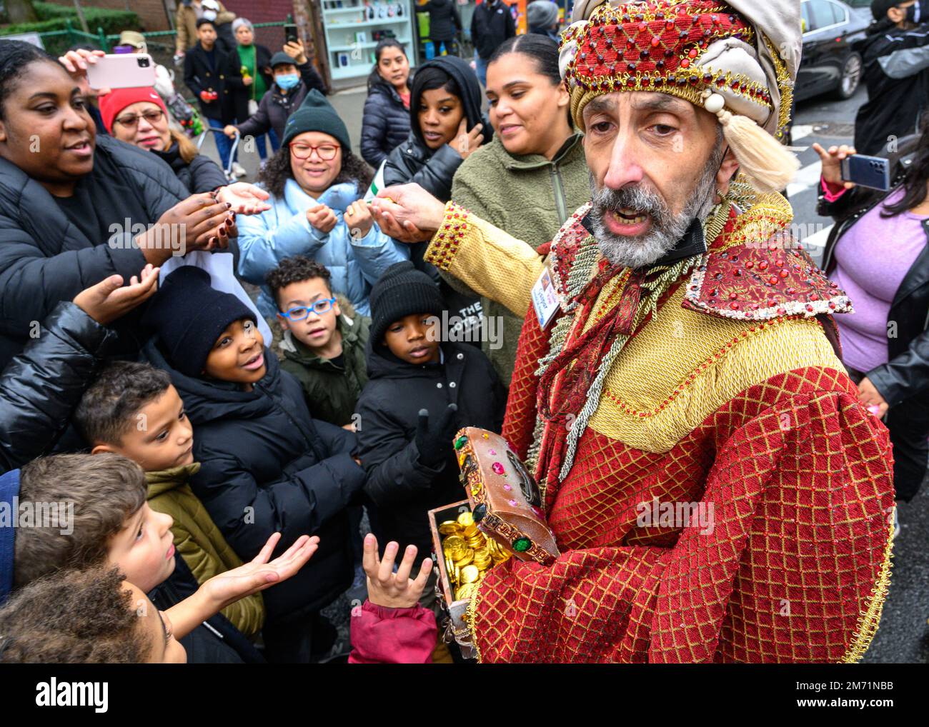 New York, USA. 6. Januar 2023. Gaspar, der Weise Mann, schenkt der Menge in East Harlem während der 46. Jährlichen Three Kings Day Parade, die vom El Museo del Barrio organisiert wird, Schokoladenmünzen. Die traditionelle spanische Feier fand erstmals seit Beginn der Coronavirus-Pandemie (COVID-19) persönlich statt. Das Thema für dieses Jahr war: „Entre Familia: Mental Health & Wellness of our Communities“ mit Schwerpunkt auf der Bedeutung von psychischer Gesundheit und Wellness. Kredit: Enrique Shore/Alamy Live News Stockfoto