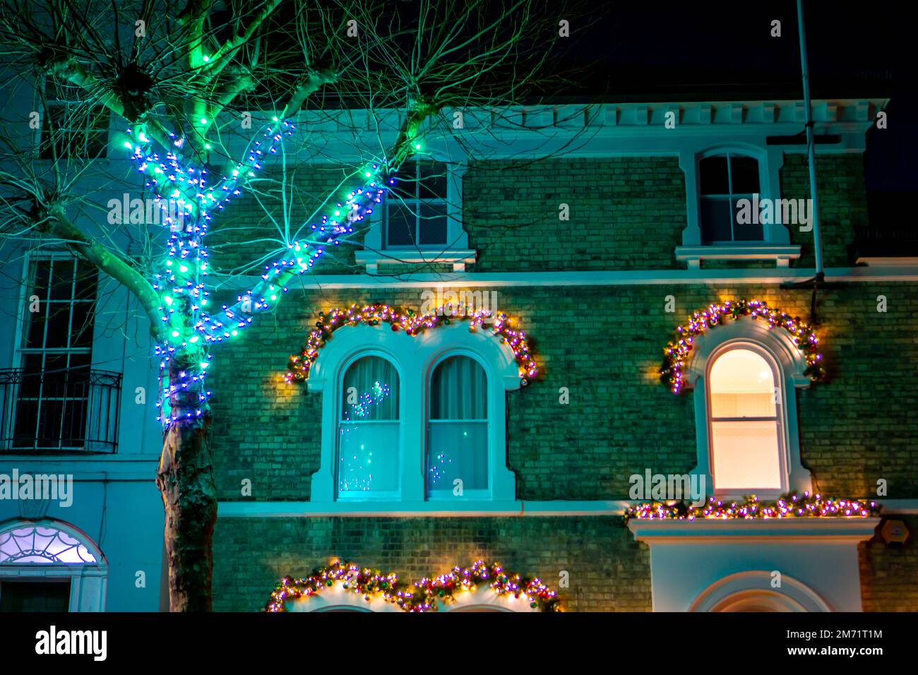 Weihnachtsdekorationen an einem Haus und beleuchteter Baum in Saffron Walden Stockfoto