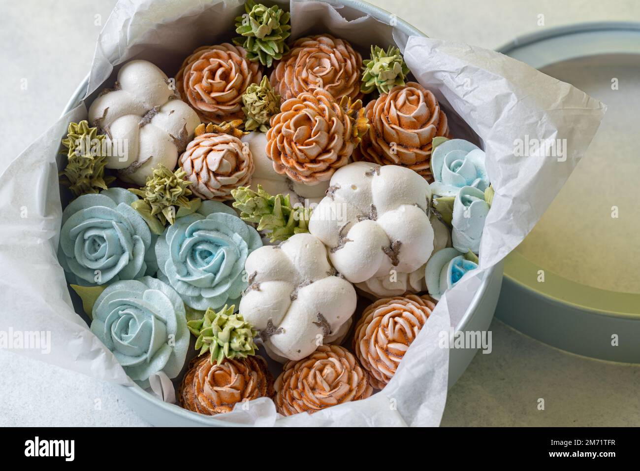 Zephyr-Blumenstrauß in einer Geschenkbox auf hellem Hintergrund. Stockfoto
