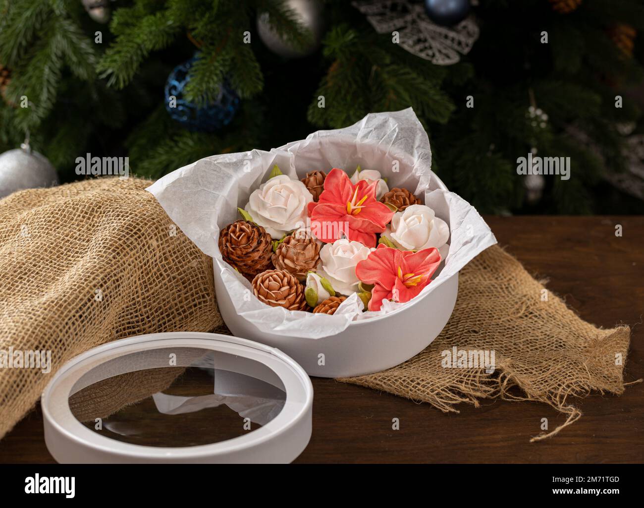 Marshmallow-Blumenstrauß in einer Geschenkbox auf dem Hintergrund eines Weihnachtsbaums, das Konzept einer festlichen Stimmung. Stockfoto