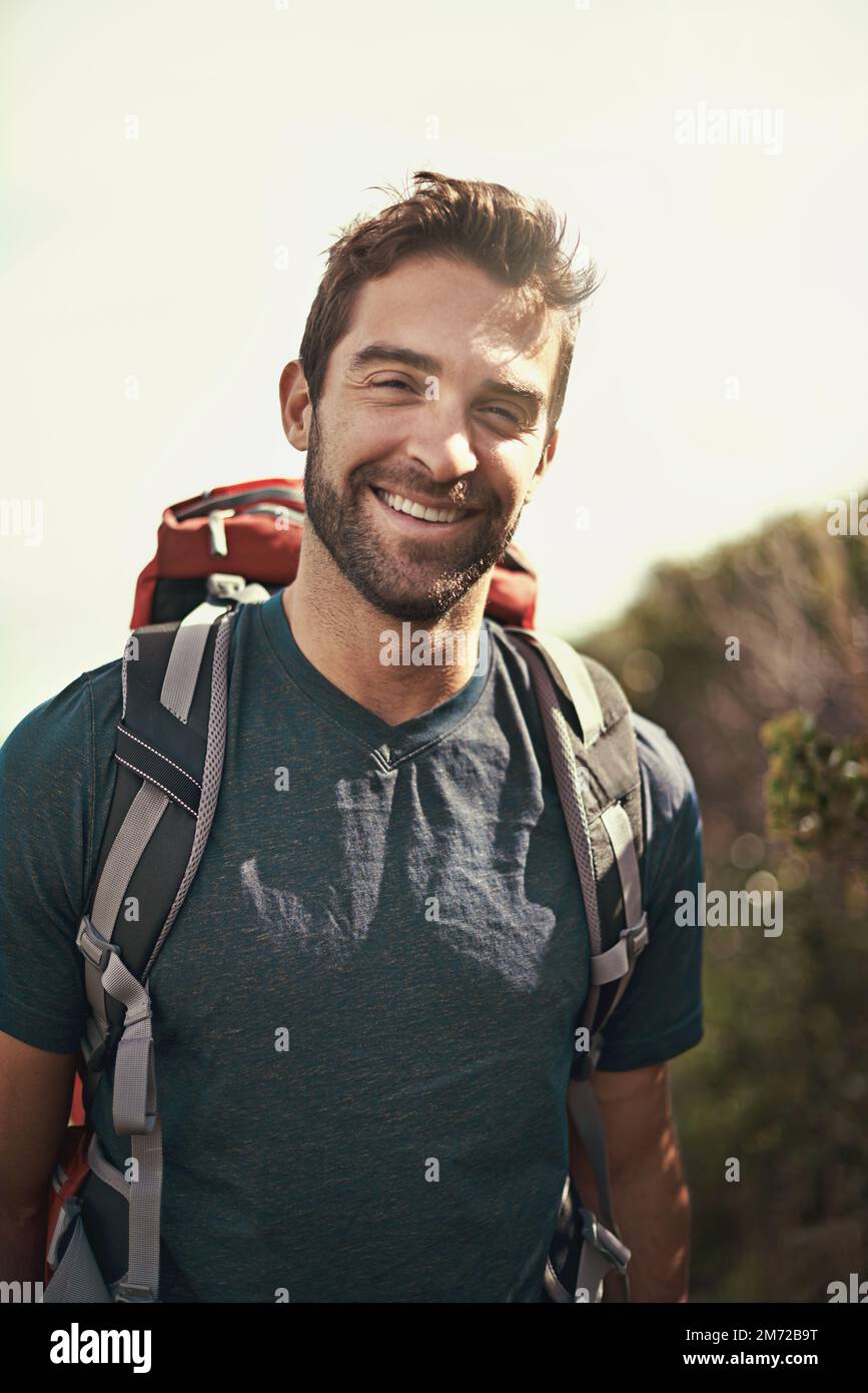 Er liebt Wandern. Gekürztes Porträt eines jungen Mannes, der in der Natur wandert. Stockfoto