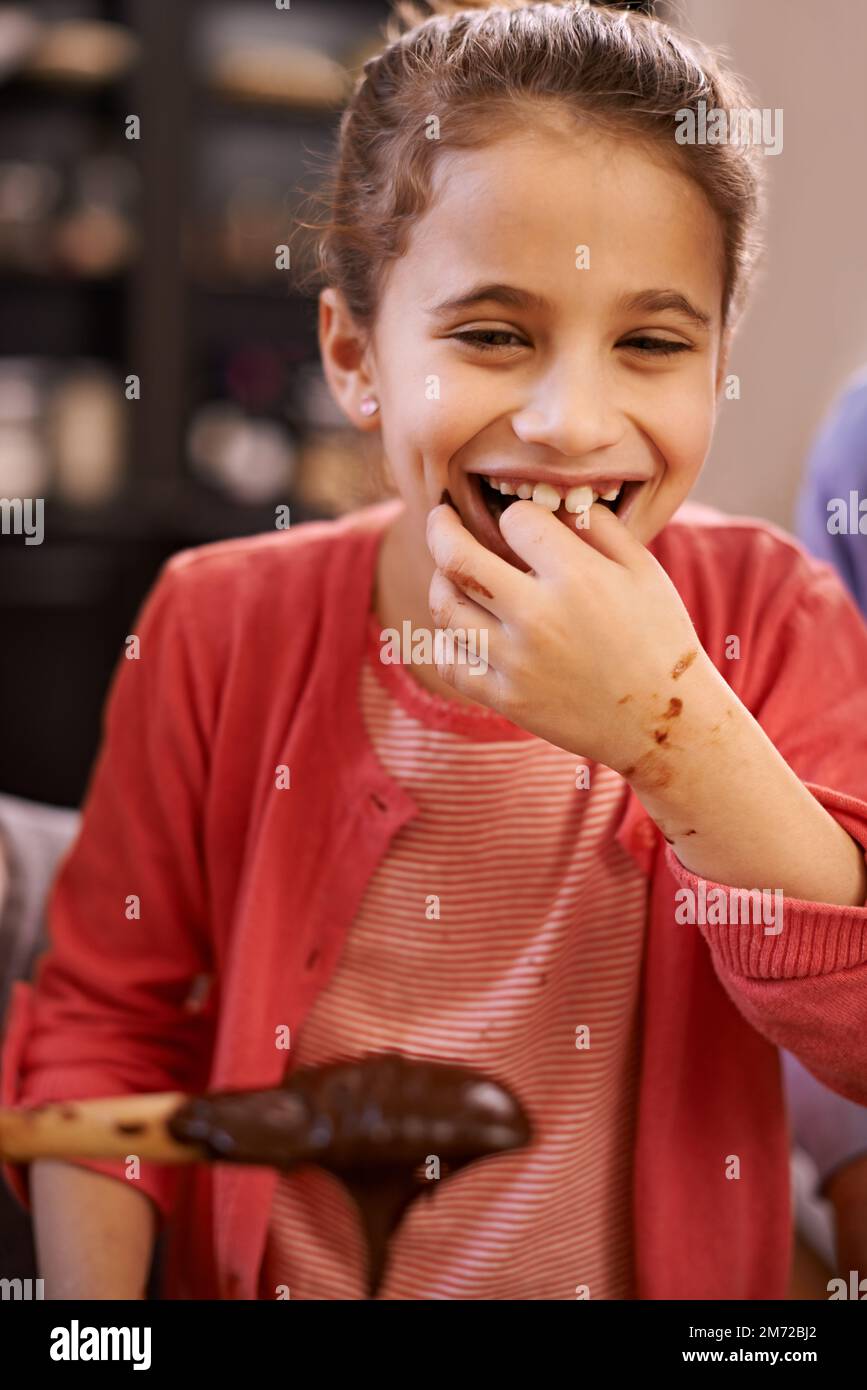 Zu köstlich, um zu widerstehen. Ein kleines Mädchen, das Spaß beim Backen hat. Stockfoto