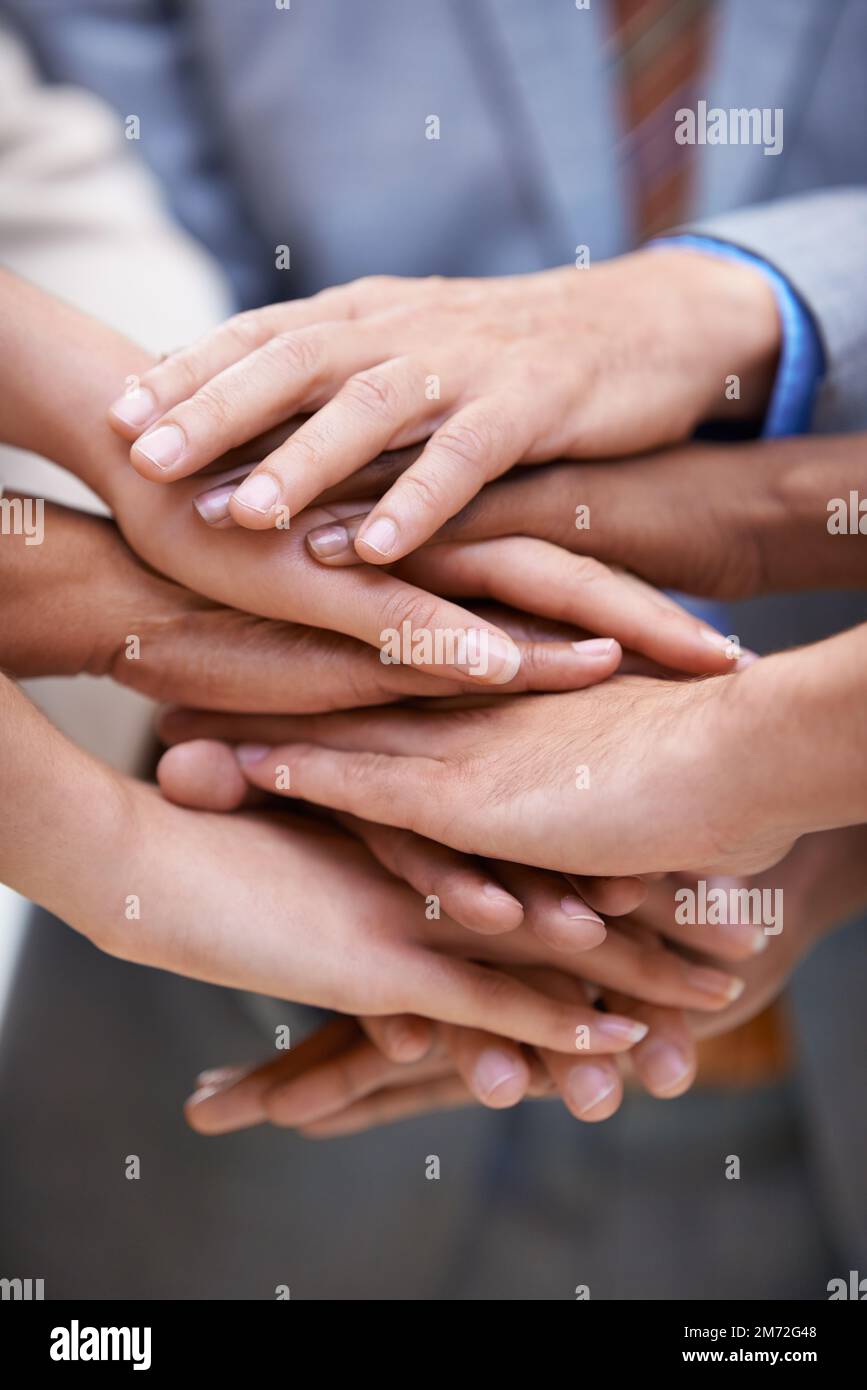 Wirtschaft und Divergenz. Eine Gruppe von Geschäftsleuten, die ihre Hände in einer Einheit zusammenlegen. Stockfoto