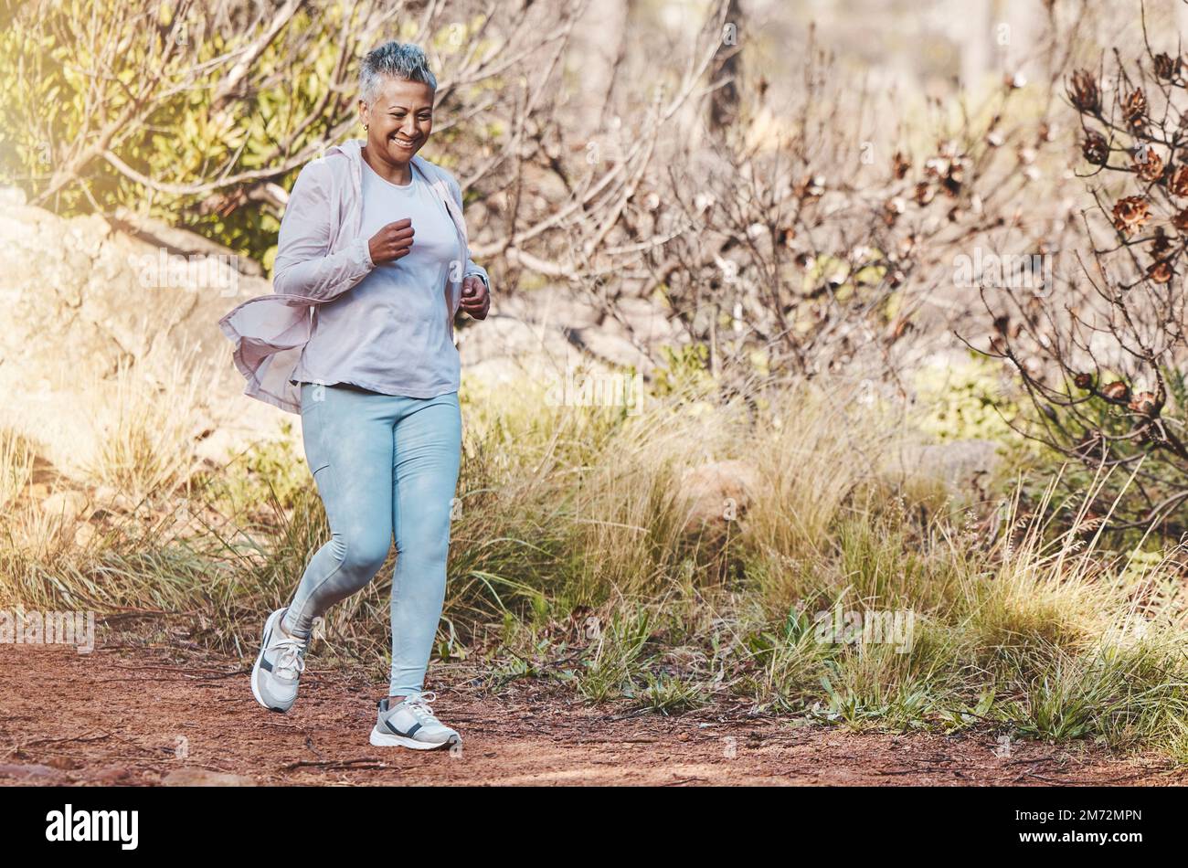 Laufen, Fitness und Seniorin in der Natur für Marathontraining, Sportgesundheit und Seniorenkardiographie in Indonesien. Lächeln, Training und glückliche ältere Menschen Stockfoto