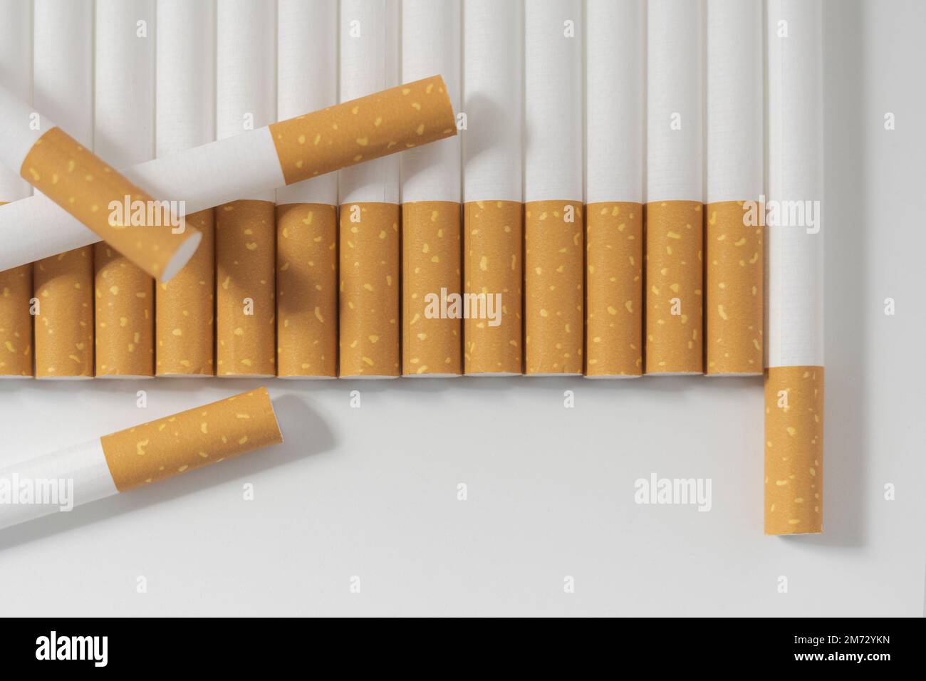 Viele Zigaretten hintereinander auf weißem Hintergrund. Nahaufnahme Stockfoto