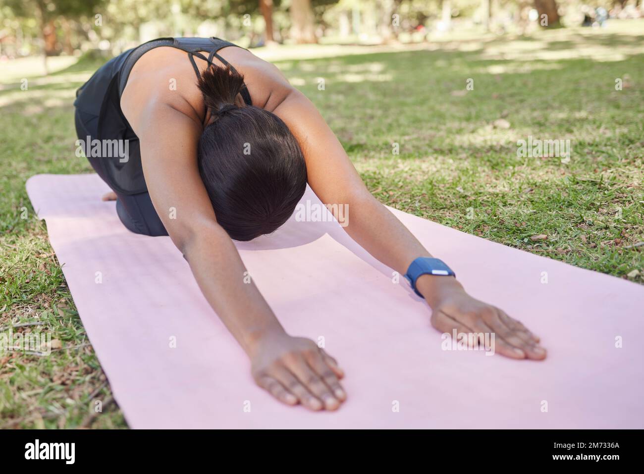 Schwarze Frau, Stretching oder Naturpark Yoga auf Matte in für Zen Gesundheit Wellness, Entspannungsübung oder Training Friedenstraining. Kinder-Pose, Fitness-Yoga Stockfoto