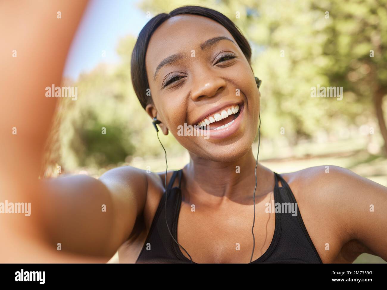 Fitness, Selfie und schwarze Frau im Park für Workout, Bewegung und einen gesunden Lebensstil mit Musik. Porträt, Lächeln und weibliche Sportlerin, die Fotos macht Stockfoto