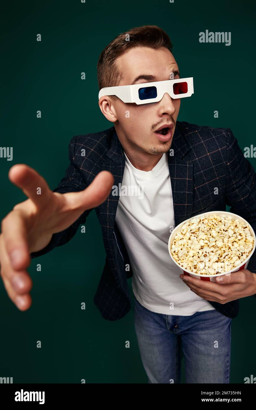 Ein Mann in 3D-Brille mit einem großen Eimer Popcorn Stockfoto