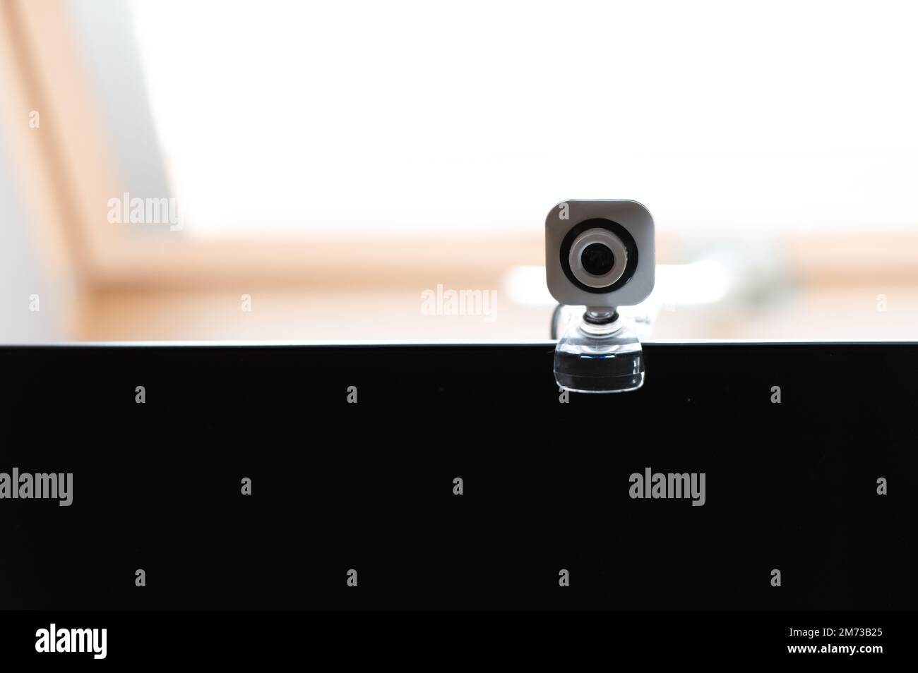 Webcam über dem Computerbildschirm. Weiße Webcam über schwarzem Bildschirm. Digitales Sicherheitskonzept Stockfoto