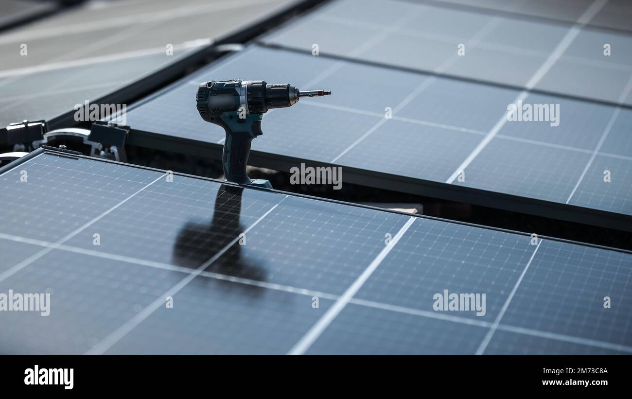 Schraubendreher zur Befestigung von Solarpaneelen an einem Firmendach Stockfoto