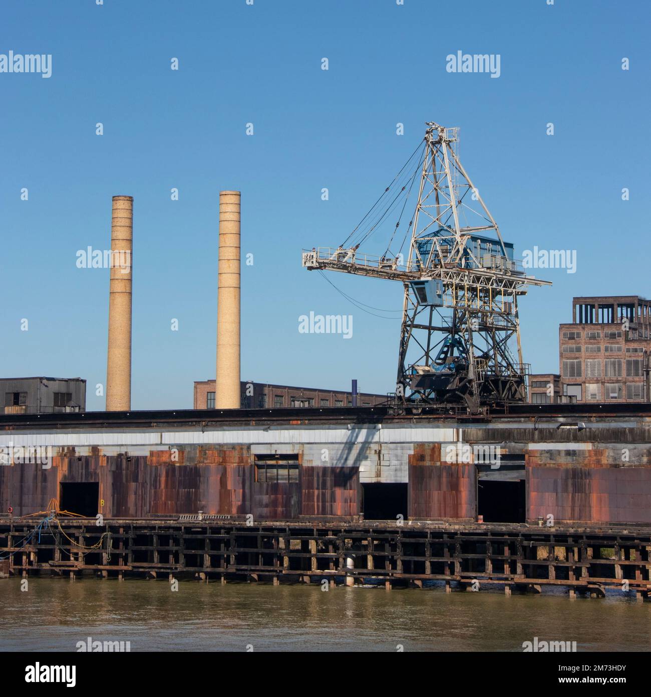 Großes Industriewerk am Ufer des Mississippi in Louisiana mit rostigem Industriekran und großen Schornsteinen Stockfoto
