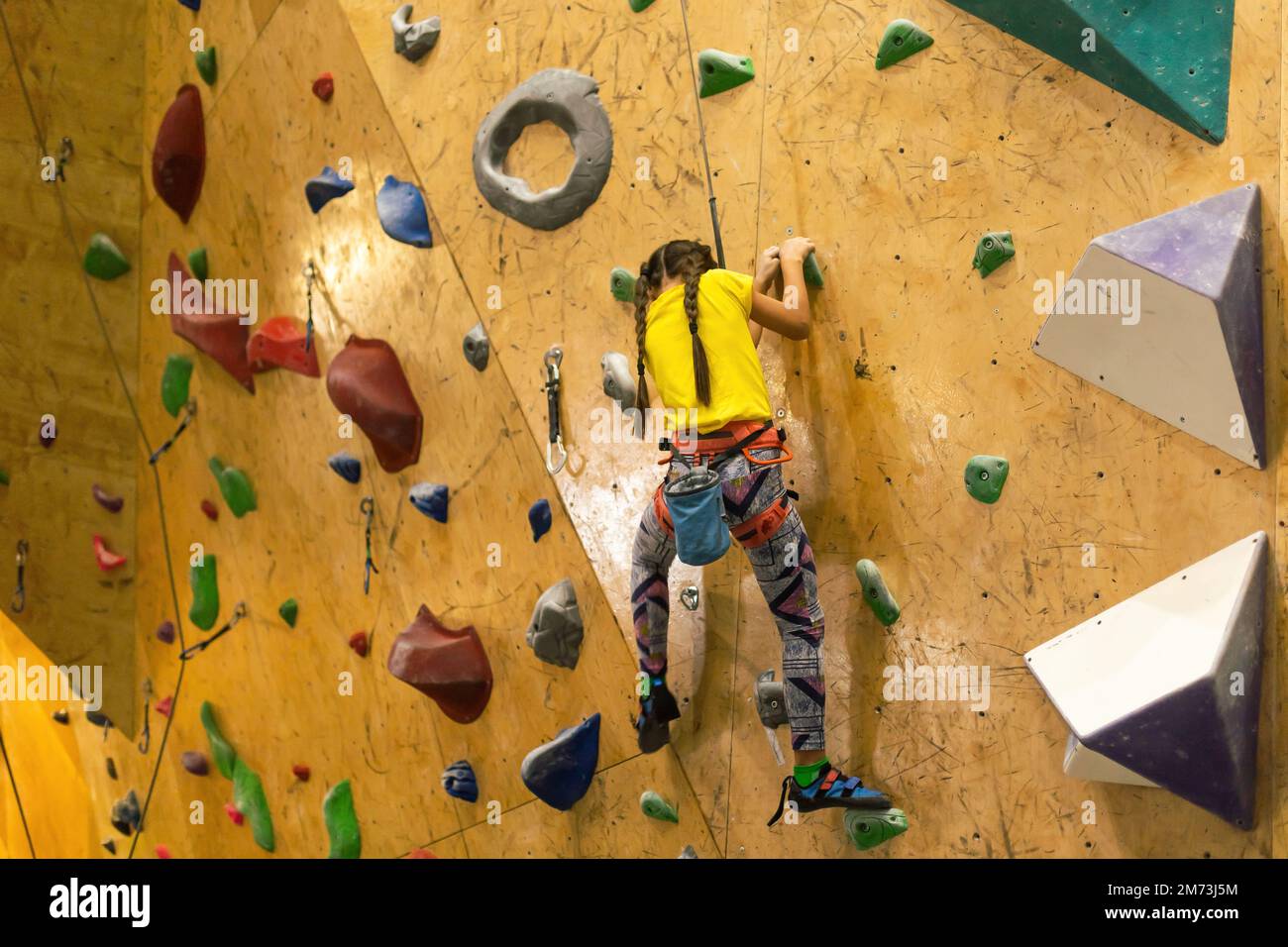 Bouldern, kleines Mädchen Klettert die Wand Stockfoto