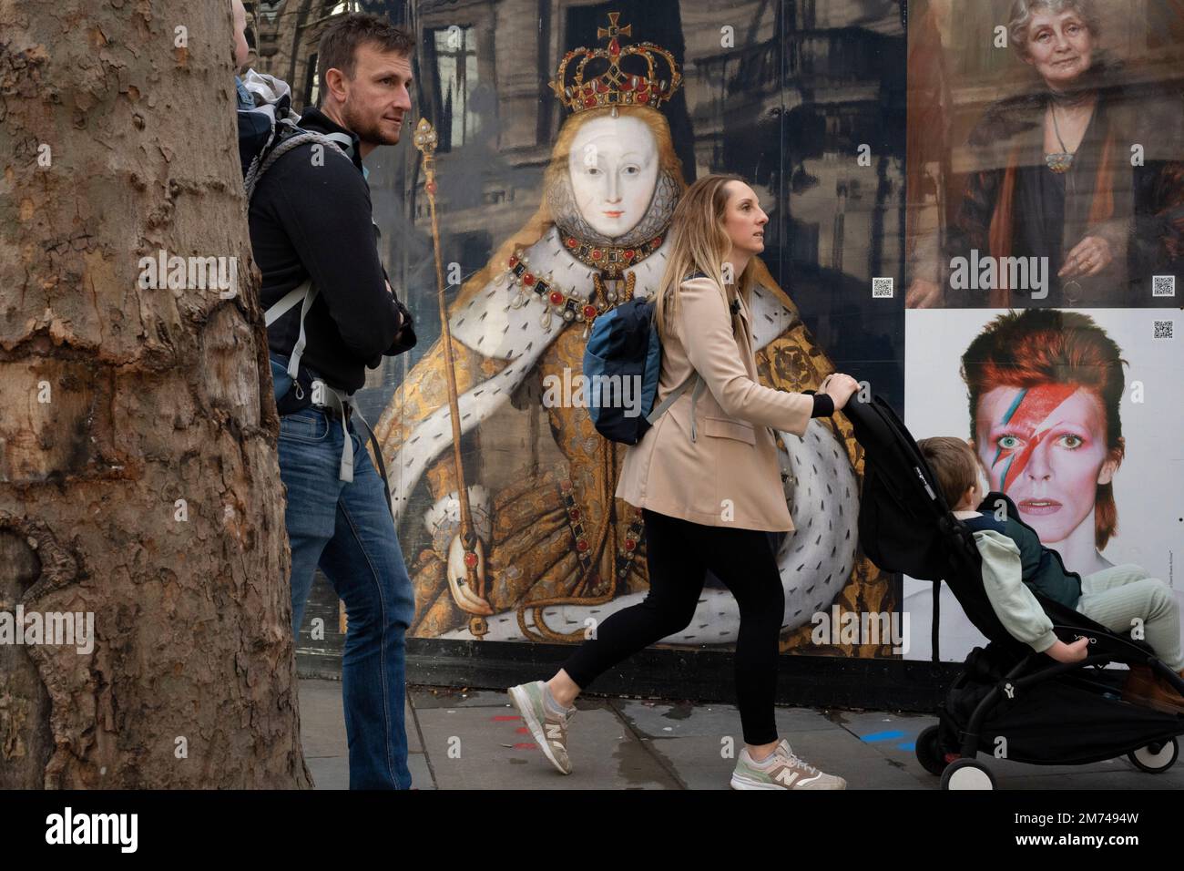 Mitglieder des öffentlichen Spaziergangs vorbei an Reproduktionen von Königin Elizabeth I, Emmeline Pankhurst und David Bowie druckten auf Baubefestigungen rund um die nationale Portrait Gallery, die am 6. Januar 2022 in London, England, renoviert wird. Stockfoto