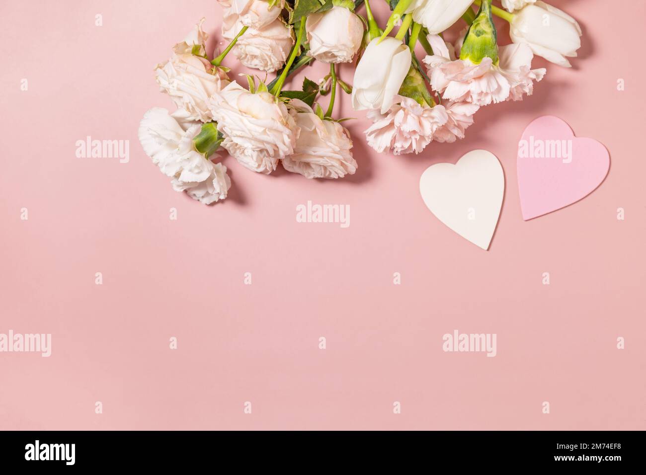 Valentinstag-Grußkarte mit wunderschönen Blumen auf pinkfarbenem Hintergrund. Valentinstag, Frauentag, Hochzeit, Geburtstag oder Muttertag. Blick von oben Stockfoto