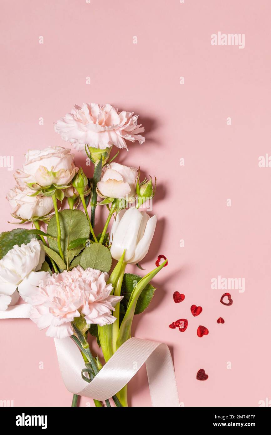 Valentinstag-Grußkarte mit wunderschönen Blumen und Herzen auf pinkfarbenem Hintergrund. Valentinstag, Frauentag, Hochzeit, Geburtstag oder Muttertag. Vie Stockfoto