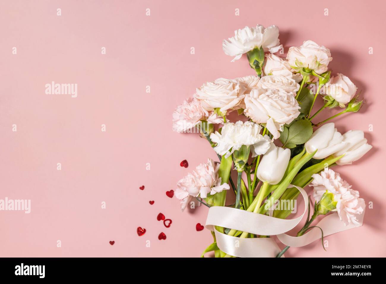 Valentinstag-Grußkarte mit wunderschönen Blumen und Herzen auf pinkfarbenem Hintergrund. Valentinstag, Frauentag, Hochzeit, Geburtstag oder Muttertag. Vie Stockfoto