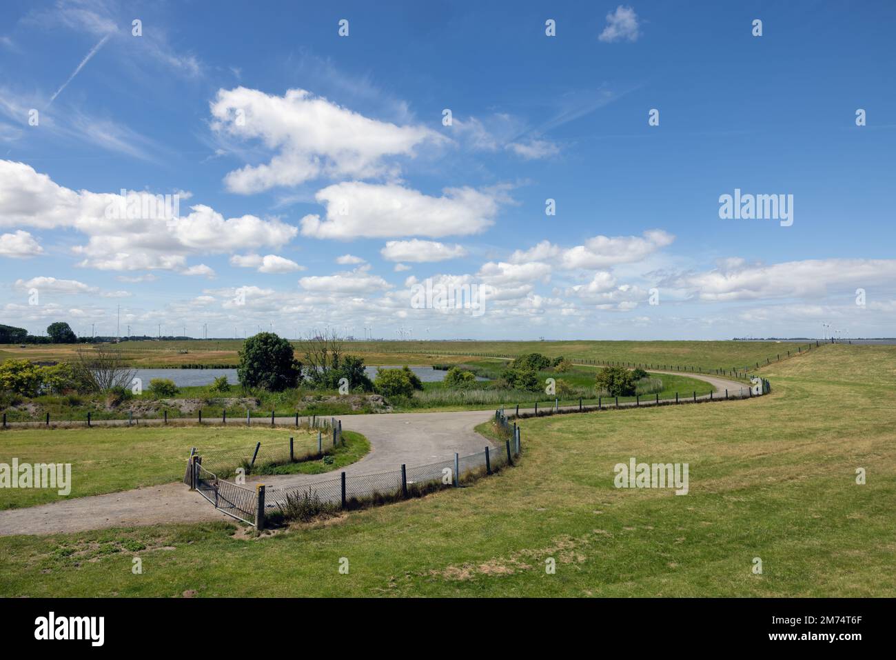 Landstraße entlang des Deichs in der niederländischen Provinz Groningen bei Punt van Reide Stockfoto