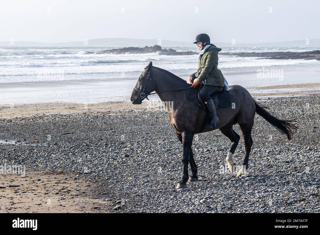 Garrylucas Beach, West Cork, Irland. 7. Januar 2023. Met Eireann hat eine gelbe Wetterwarnung für fünf Bezirke ausgegeben. Die gelbe Windwarnung gilt für die Grafschaften Kerry, Clare, Galway, Mayo und Donegal und gilt bis morgen früh um 08,00 Uhr (so 8. Uhr). Alison Chambers aus Garretstown nahm ihr Pferd 'TJ' für eine Fahrt am Strand mit. Kredit: AG News/Alamy Live News Stockfoto