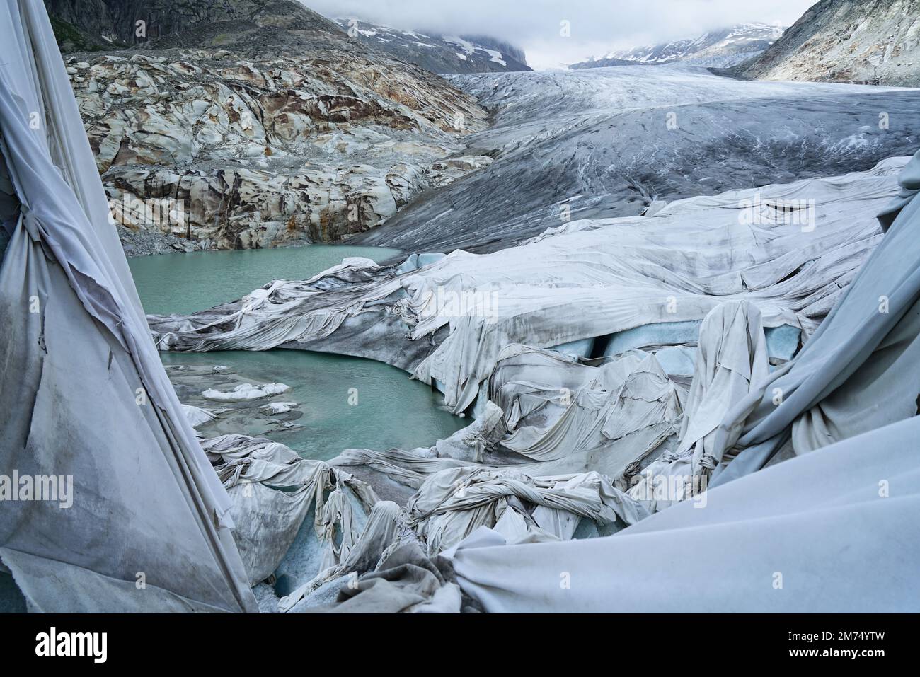 Das Schmelzen des Rhongletschers ist das sichtbarste Zeichen des Klimawandels. Aufgrund der hohen Temperaturen können weiße Laken den Gletscher nicht mehr schützen Stockfoto