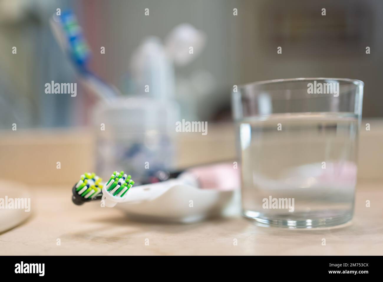 Elektrische Zahnbürsten mit einem Glas Wasser und anderen Gegenständen für die Zahnhygiene, Foto mit Kopierraum. Stockfoto