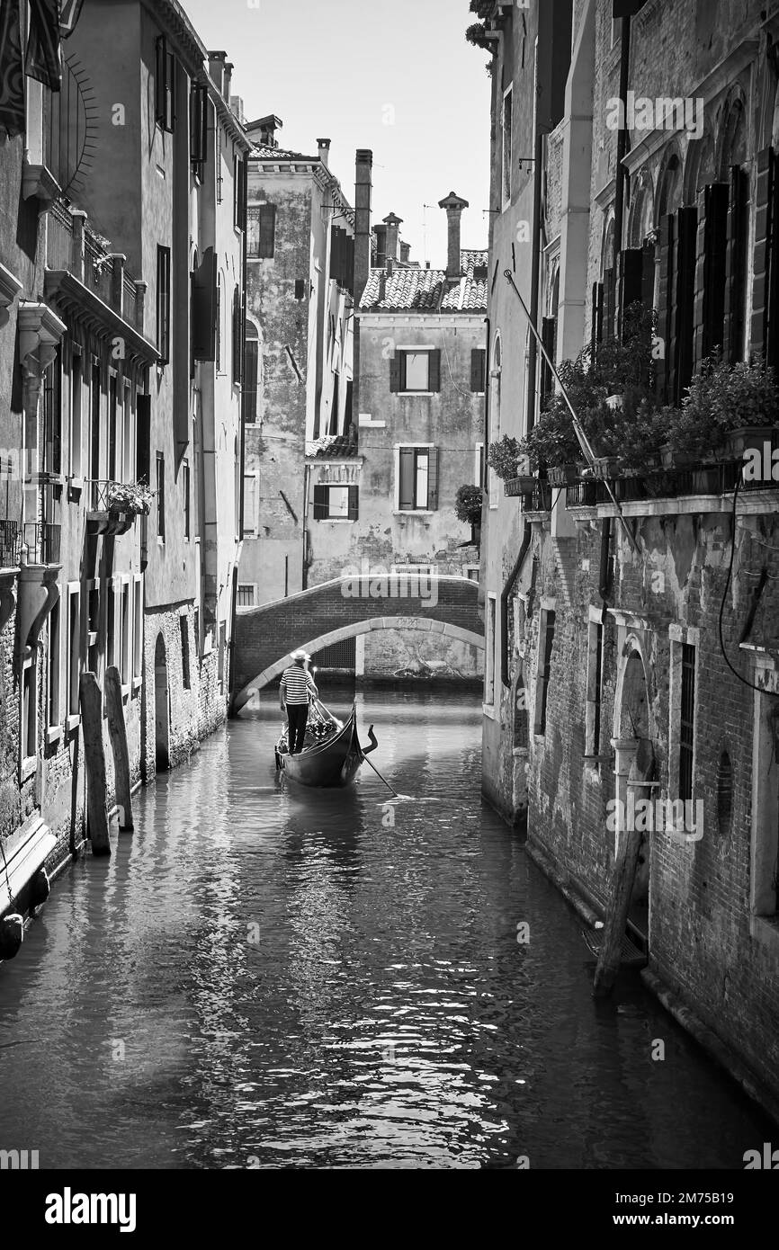 Kanal in Venedig mit Gondel. Schwarzweißfotografie Stockfoto