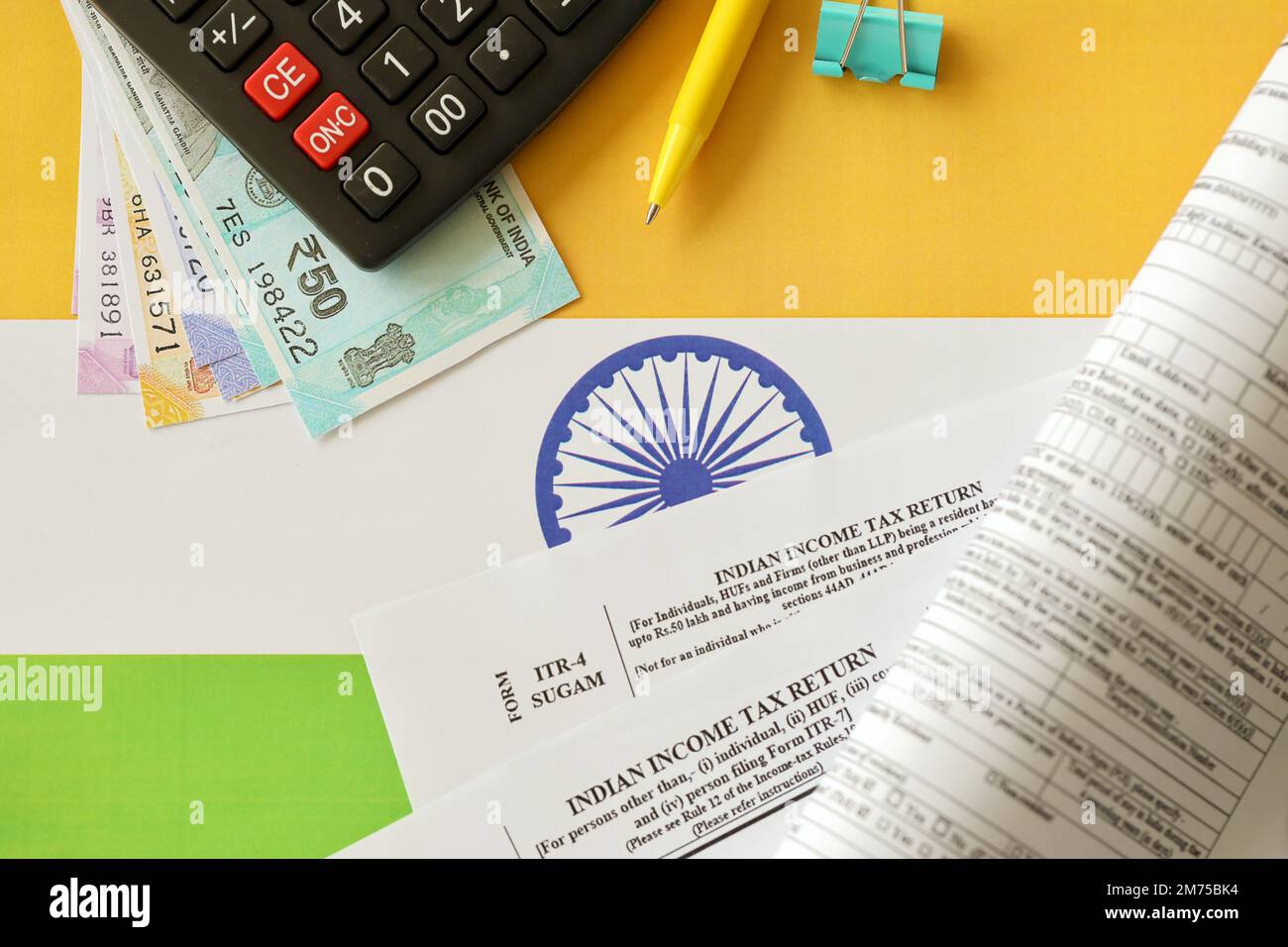 KIEW, UKRAINE - 4. MAI 2022 Indische Einkommensteuererklärung, leeres Formular mit Stift- und indischen Rupien-Rechnungen auf indischer Landesflagge. Konzept der jährlichen Steuermeldung Stockfoto