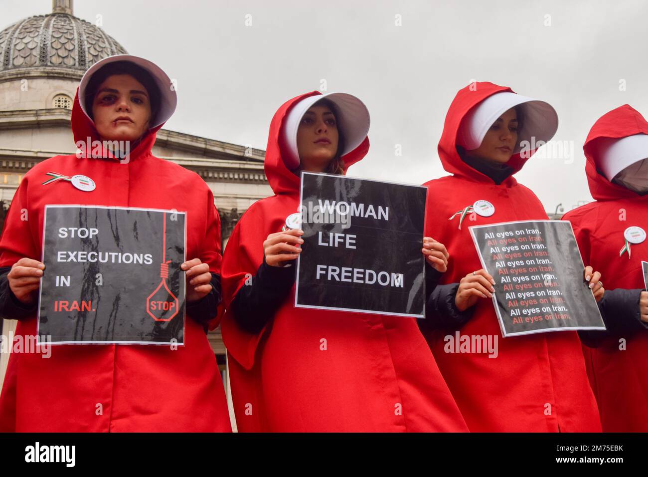 London, Großbritannien. 07. Januar 2023. Demonstranten halten während der Demonstration am Trafalgar Square die Plakate "Frauen leben frei" und "Hinrichtungen im Iran stoppen". Frauen, die Kostüme aus dem Magazin trugen, und einige mit gefälschten blauen Flecken im Gesicht, marschierten durch Central London, um gegen die Hinrichtungen im Iran zu protestieren, um die Freiheit zu unterstützen und um sich mit Frauen im Iran solidarisch zu zeigen. Kredit: SOPA Images Limited/Alamy Live News Stockfoto