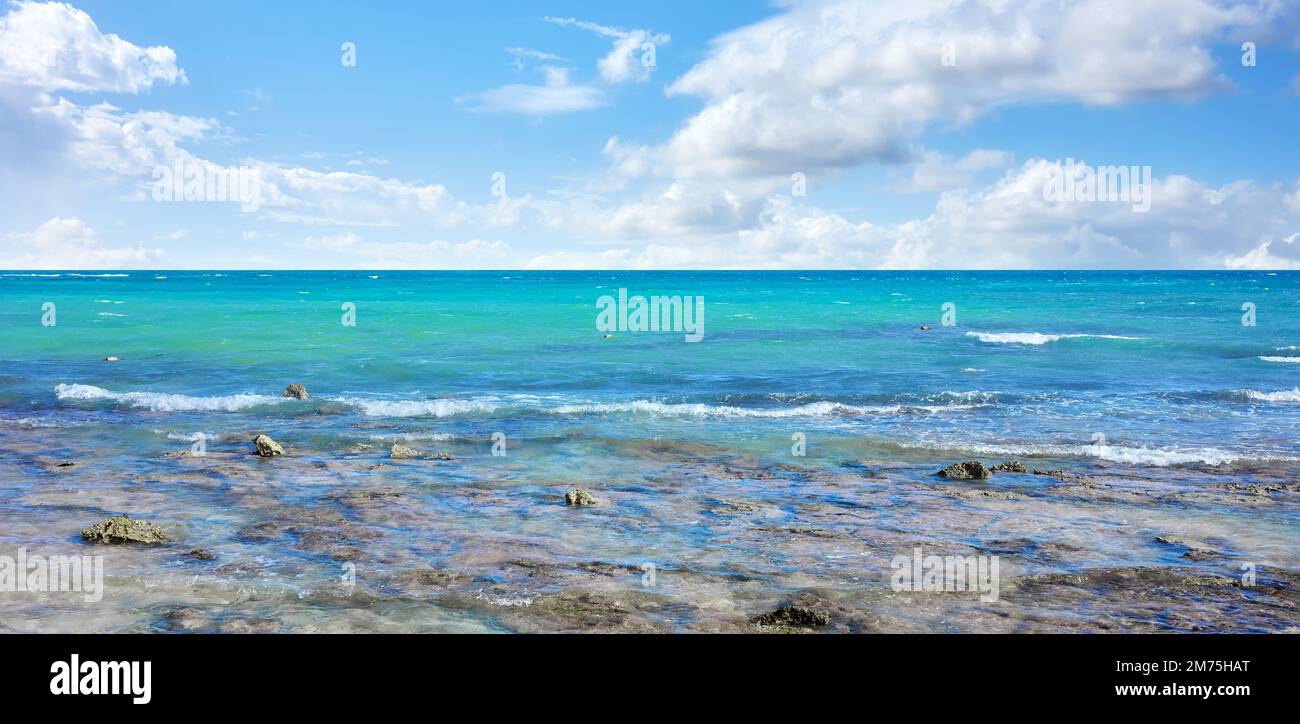 Karibische Meereslandschaft mit Felsen im flachen Wasser an einem sonnigen Tag. Stockfoto