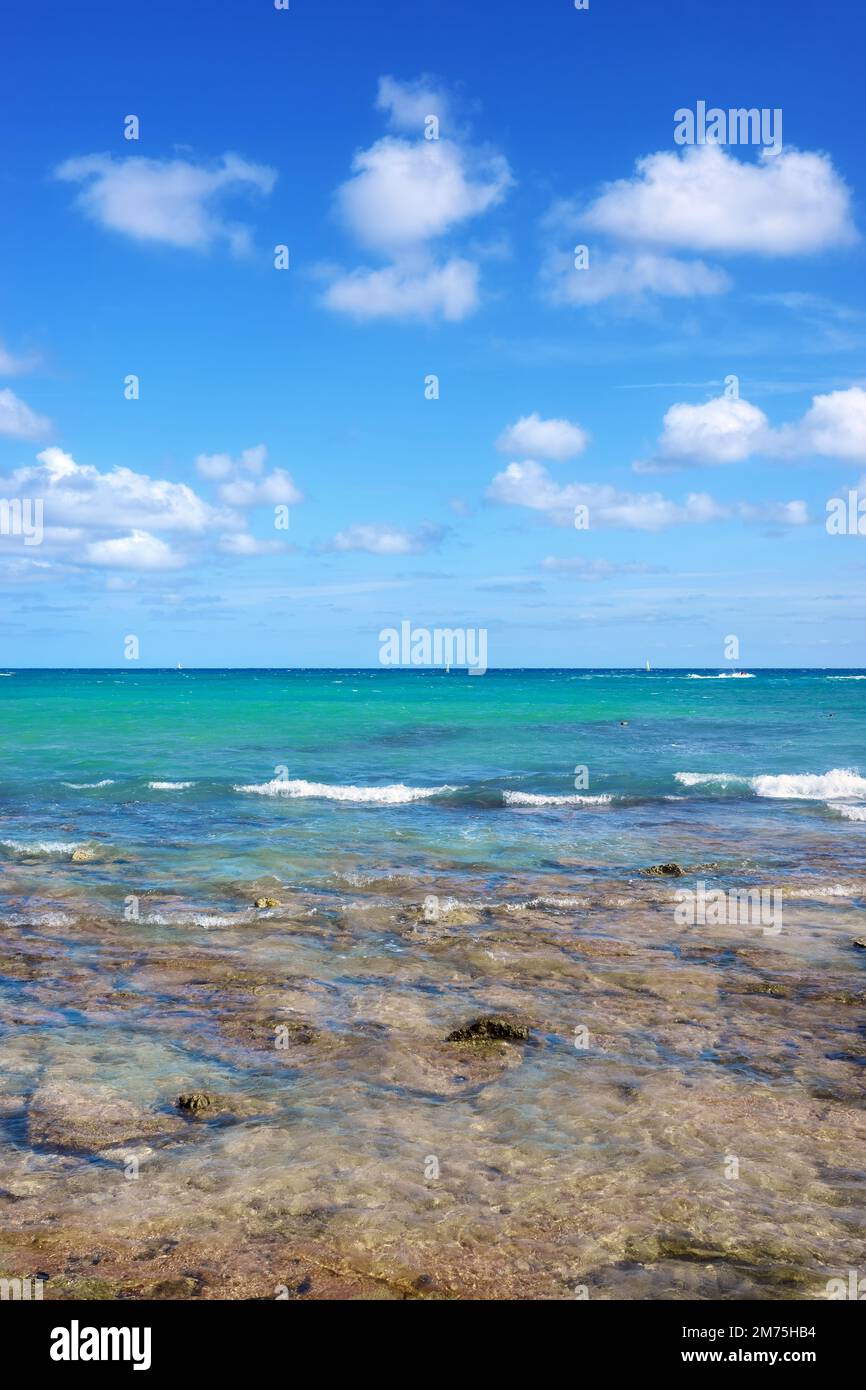 Karibische Meereslandschaft mit Felsen im flachen Wasser an einem sonnigen Tag. Stockfoto