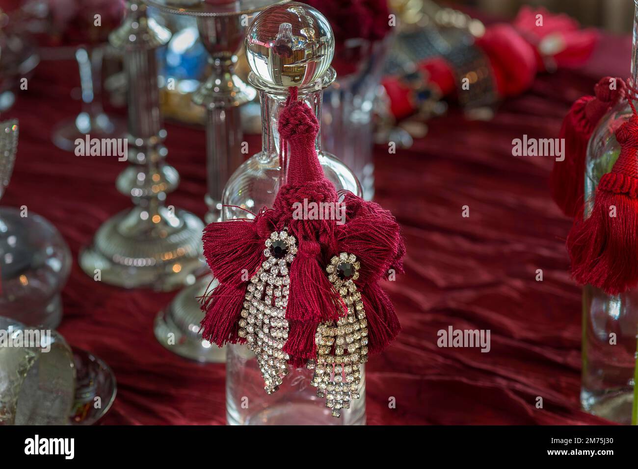 Strasssteinohrringe auf einer Glasflasche, Bayern, Deutschland Stockfoto