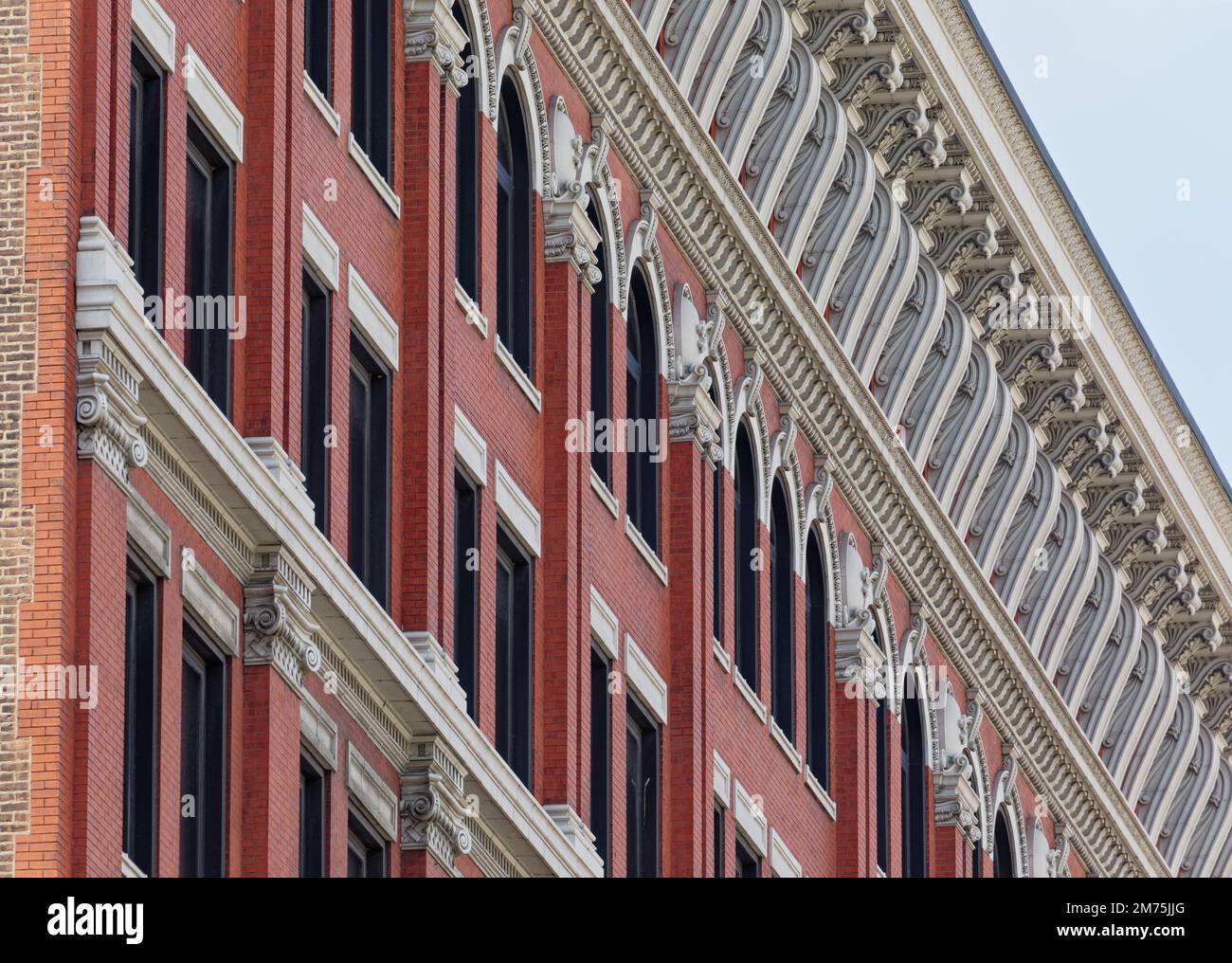 44 massive Terrakotta-Halterungen umrahmen die Fenster im obersten Stockwerk und stützen die aufwändige Fassade des Electric Building. Stockfoto