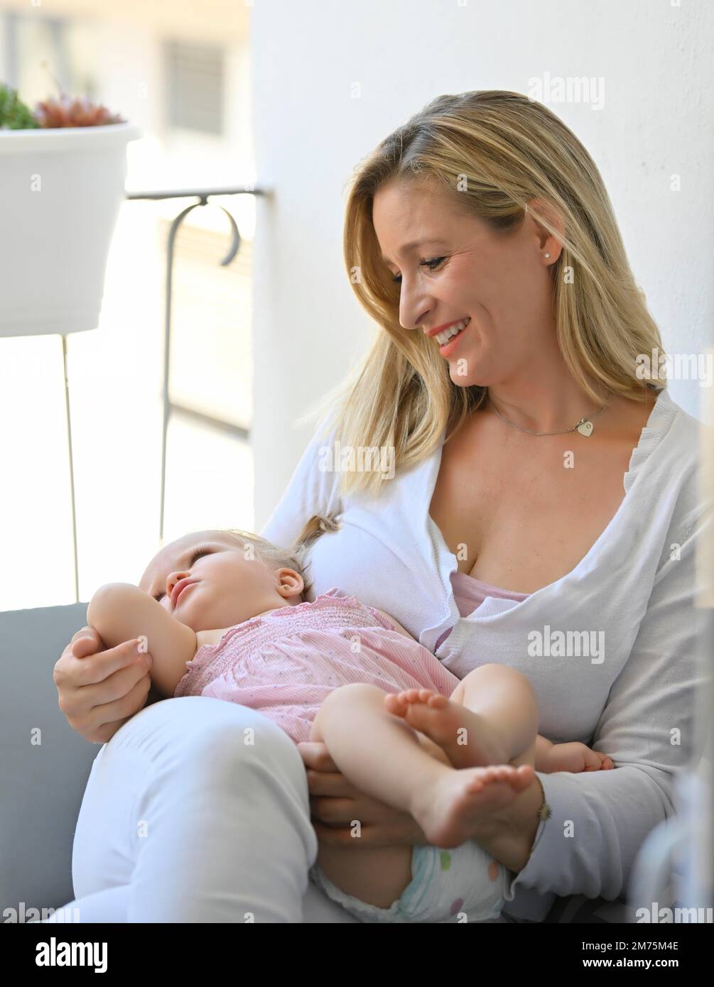 Mutter hat Mädchen, Kleinkind, 11 Monate, auf dem Schoß, Baden-Württemberg, Deutschland Stockfoto