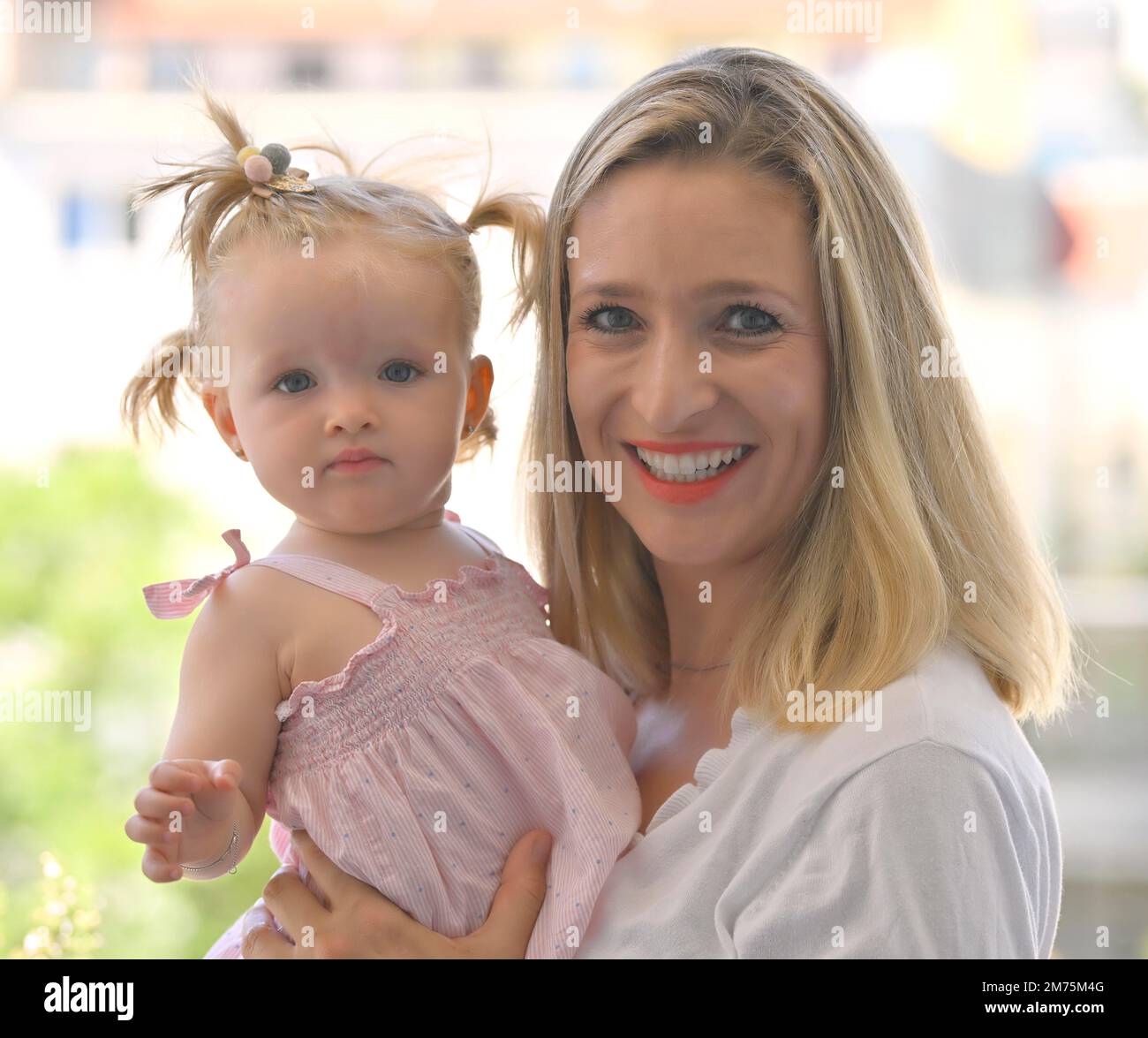 Mutter hat Mädchen, Kleinkind, 11 Monate, am Arm, lächelnd, Baden-Württemberg, Deutschland Stockfoto