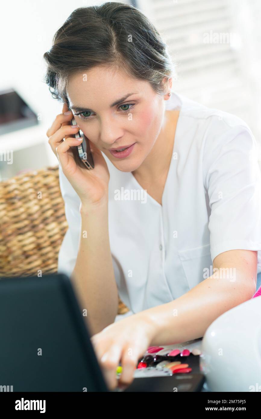 Eine Kurarbeiterin am Telefon, die ihre Agenda überprüft Stockfoto