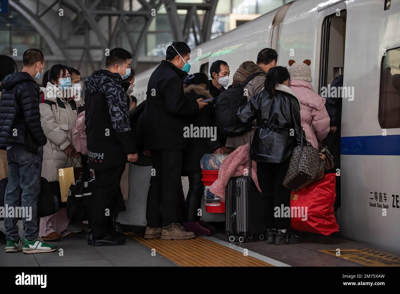 Am ersten Tag des chinesischen Frühlingsfestivals in Wuhan steigen Reisende mit Gesichtsmasken am Bahnhof Hankow in einen Zug. Am Samstag, dem ersten Tag des diesjährigen Frühjahrsfestes, werden voraussichtlich rund 6,3 Millionen Fahrten durch China unternommen, so der nationale Eisenbahnbetreiber China State Railway Group. China hat kürzlich sein epidemisches Kontrollmanagement optimiert, und auch epidemische Maßnahmen für Reisen wurden letzten Monat optimiert. Reisende brauchen keine negativen Nukleinsäuretestergebnisse oder Gesundheitscodes mehr, sind nicht verpflichtet, sich Nukleinsäuretests oder Gesundheit i zu unterziehen Stockfoto