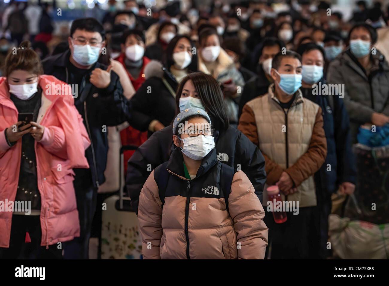 Passagiere mit Gesichtsmasken stehen am ersten Tag des chinesischen Frühlingsfestivals in Wuhan am Bahnhof Hankow in Schlange, um in einen Zug zu steigen. Am Samstag, dem ersten Tag des diesjährigen Frühjahrsfestes, werden voraussichtlich rund 6,3 Millionen Fahrten durch China unternommen, so der nationale Eisenbahnbetreiber China State Railway Group. China hat kürzlich sein epidemisches Kontrollmanagement optimiert, und auch epidemische Maßnahmen für Reisen wurden letzten Monat optimiert. Reisende benötigen keine negativen Nukleinsäuretests oder Gesundheitscodes mehr, sind nicht verpflichtet, sich einem Nukleinsäuretest zu unterziehen Stockfoto