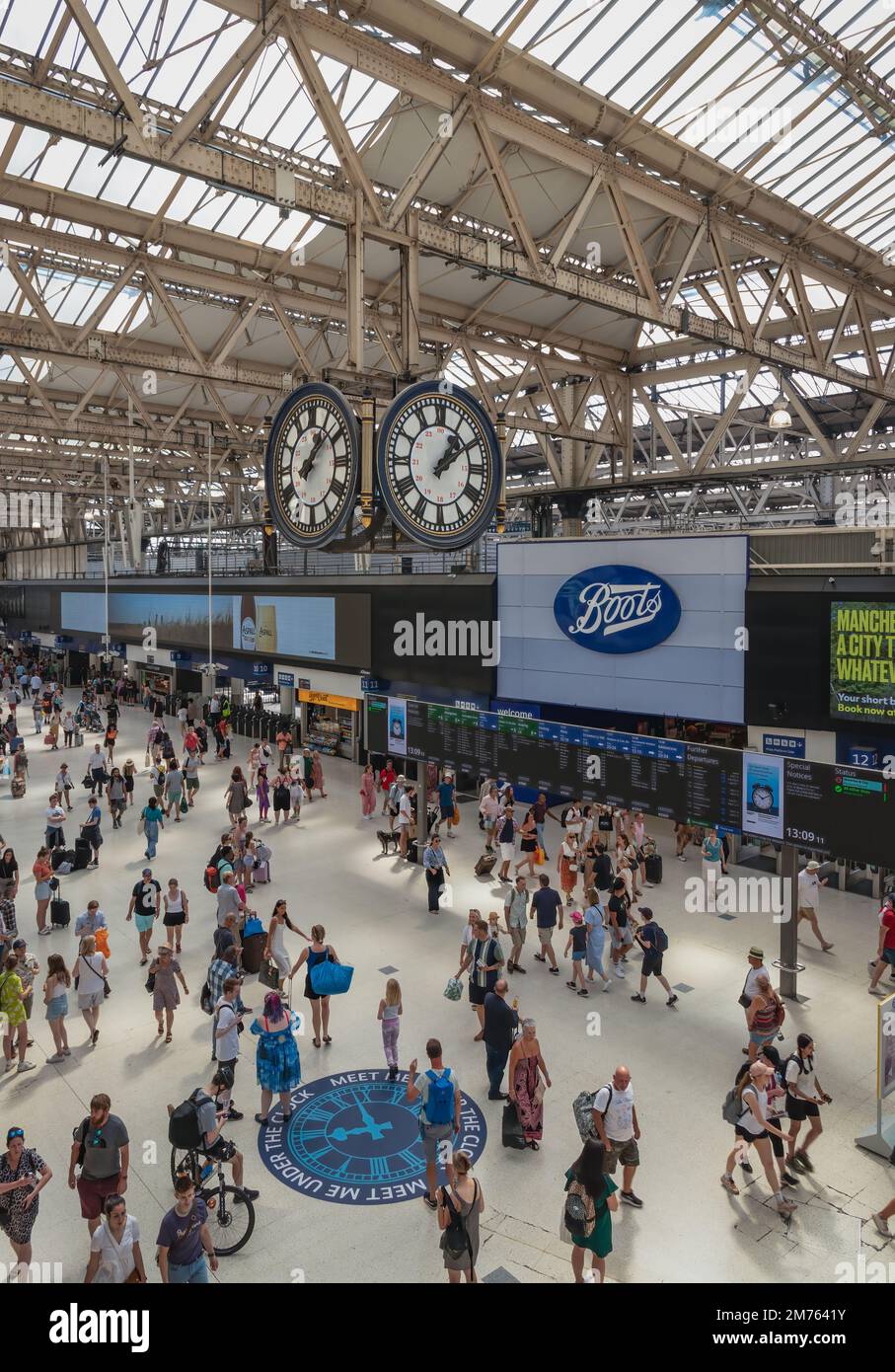 Die Uhr und die Menschen am späten Morgen in der Waterloo Station in London Stockfoto