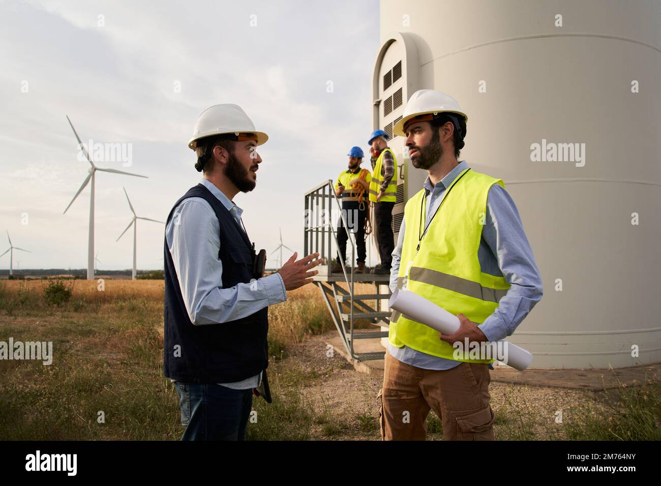 Gruppe von Ingenieuren im Windkraftwerk. Konzept für erneuerbare und saubere Energie, nachhaltige Zukunft. Stockfoto