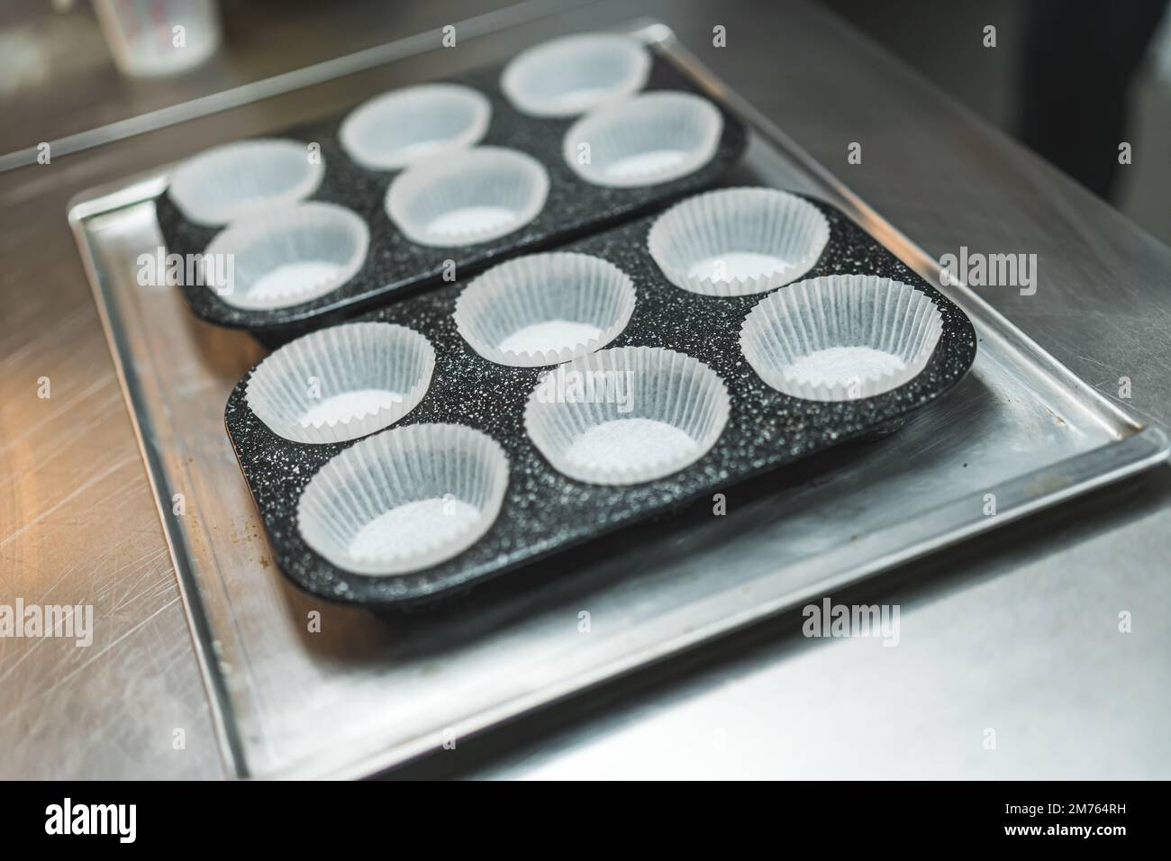 Leere weiße Cupcake-Formen aus Papier, die in den Muffin-Träger gelegt werden. Nahaufnahme. Speicherplatz kopieren. Hochwertiges Foto Stockfoto