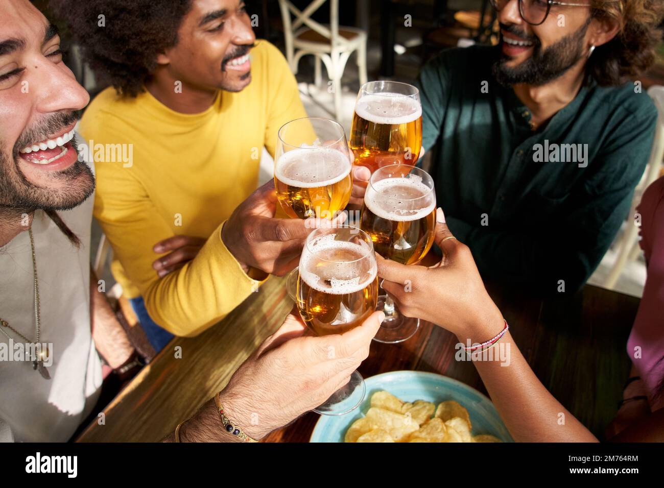Eine Gruppe von Arbeitskollegen stoßen nach der Arbeit in der Bar des Restaurants in der Happy Hour des Pubs mit Bier an Stockfoto