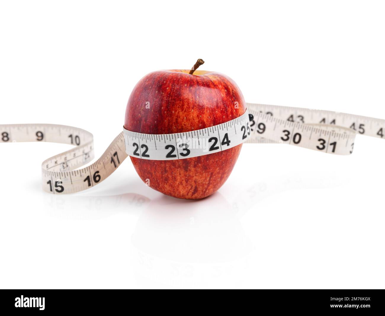 Den Fortschritt messen. Ein Studiofoto eines roten Apfels mit Maßband umwickelt. Stockfoto