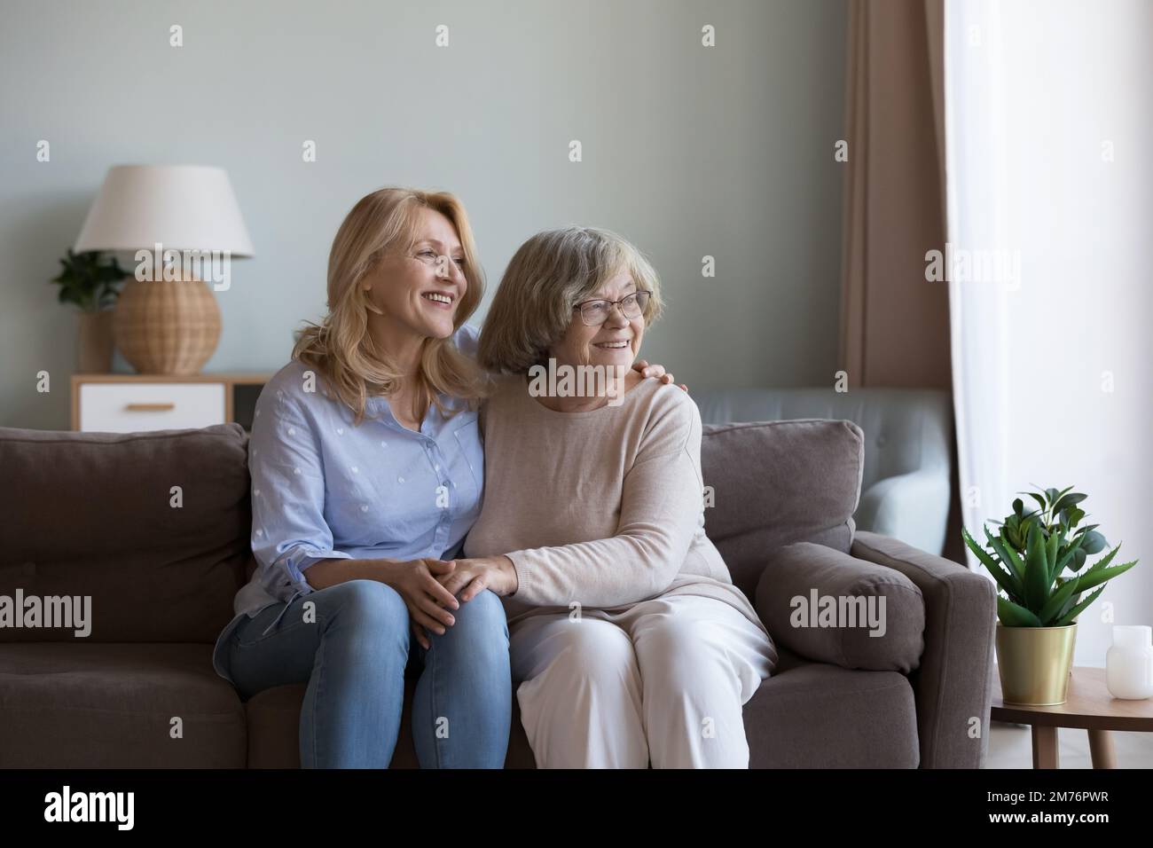Glückliche Tochter Frau und alte mutter, die in der Nähe auf dem Sofa saßen Stockfoto
