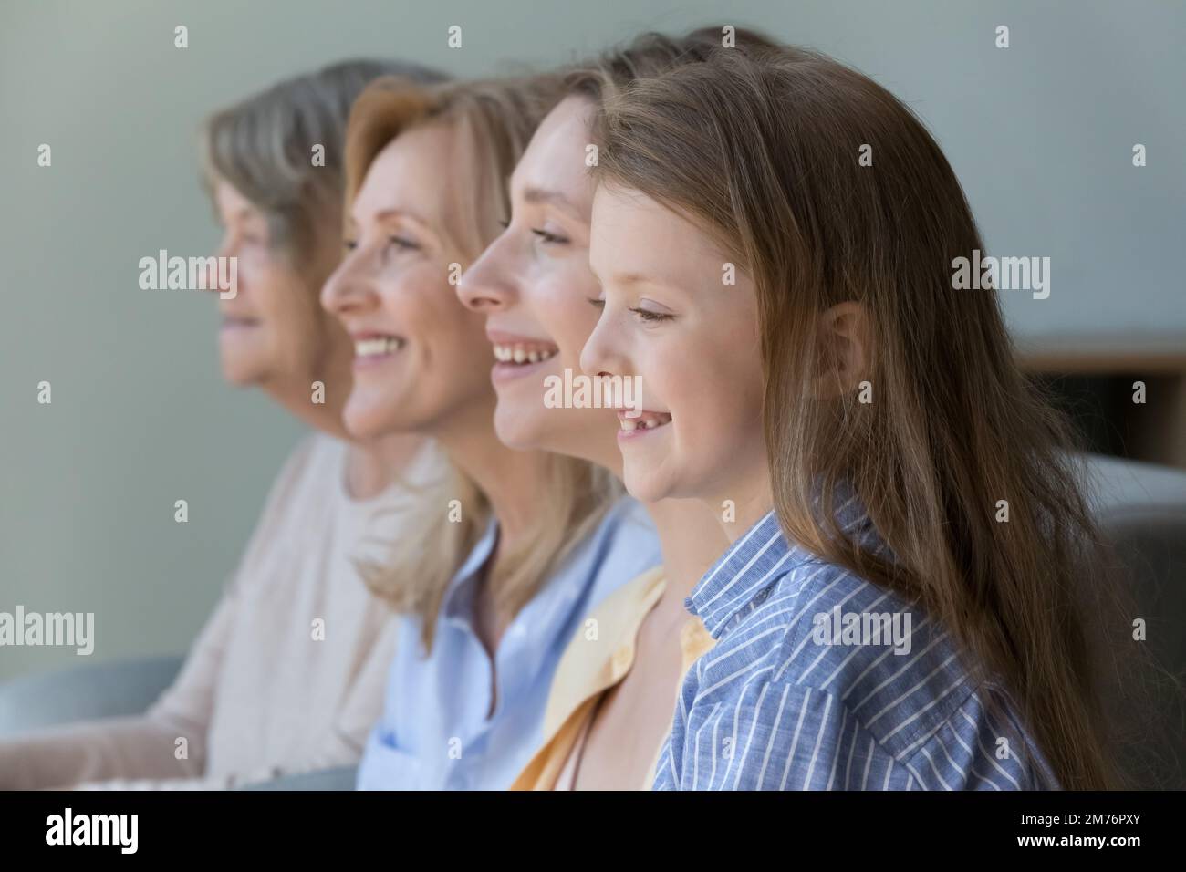 Fröhliches, süßes Mädchen, das neben der jungen mutter steht, reife Oma Stockfoto