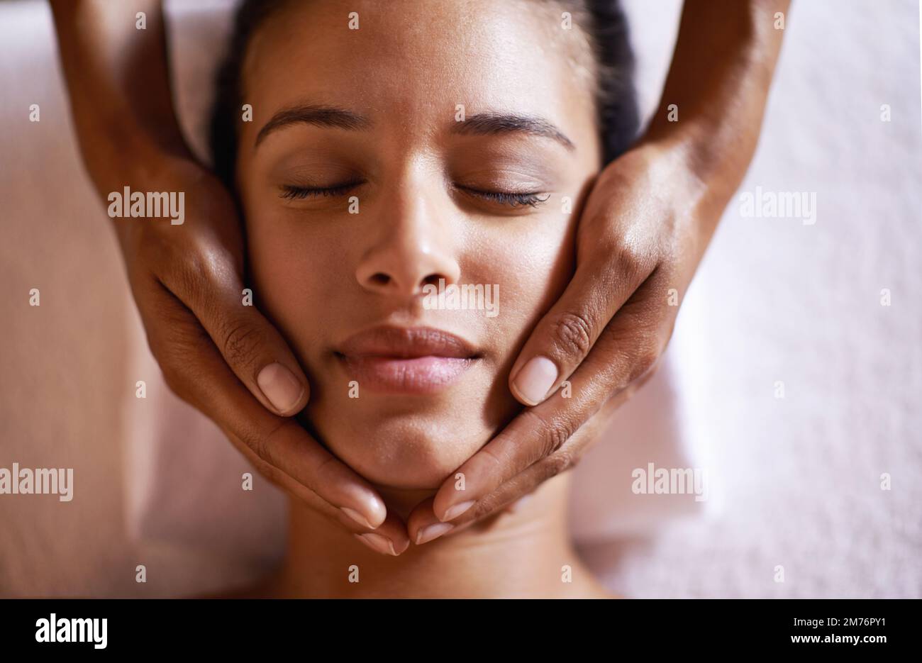 Das fühlt sich göttlich an. Eine junge Frau bekommt eine Kopfmassage in einem Schönheitssalon. Stockfoto