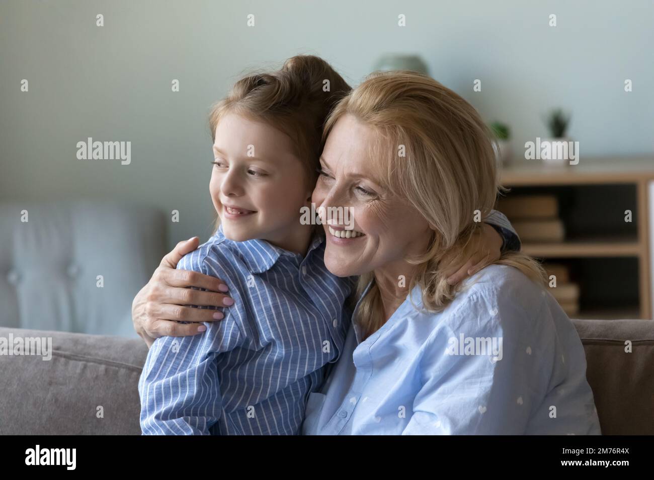 Glückliche, reife Großmutter, die das süße Enkelkind in den Armen hält Stockfoto