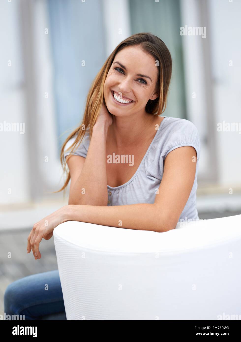 Genießen Sie einen Moment zum Entspannen. Porträt einer jungen Frau, die auf ihrem Terrassensessel sitzt. Stockfoto